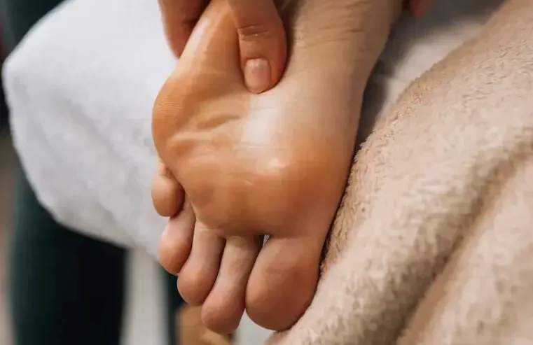 Person receiving a massage on the sole of the foot.