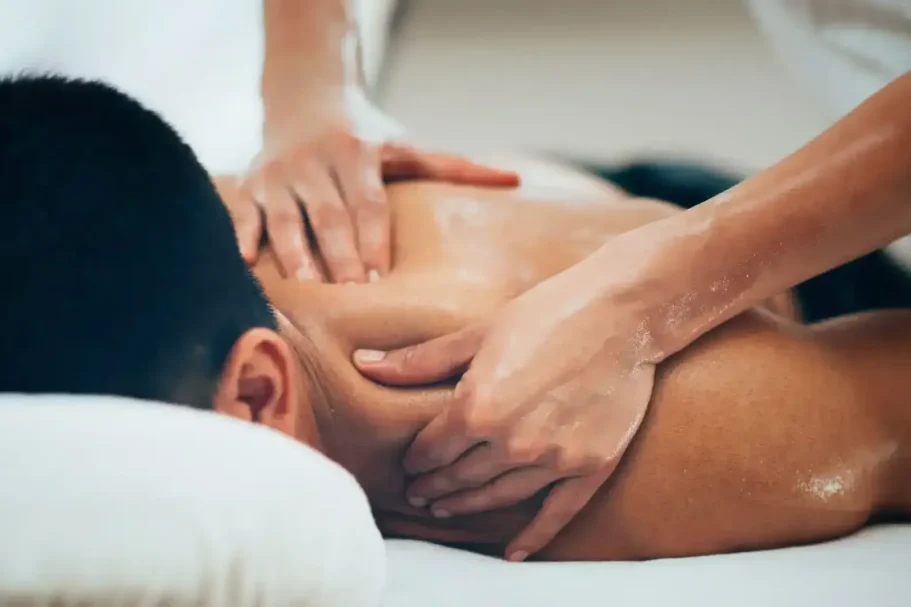Massage on a person's back, with hands applying pressure.