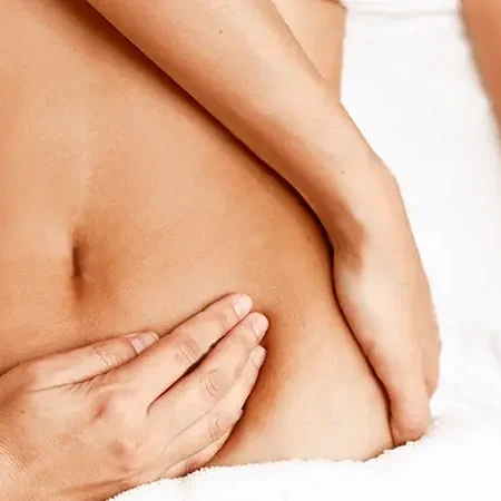 Massage therapist's hands performing an abdominal massage in Marbella