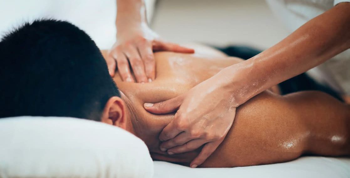 Person receiving a back massage in a relaxing environment at home