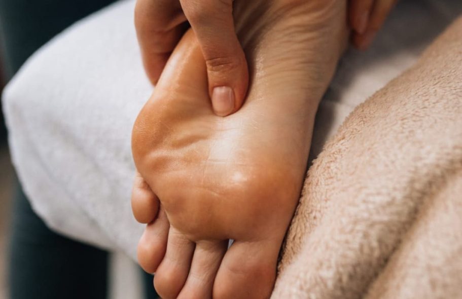 Person receiving a massage on the sole of the foot.