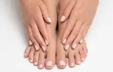 Hands and feet with manicured nails, on white background.