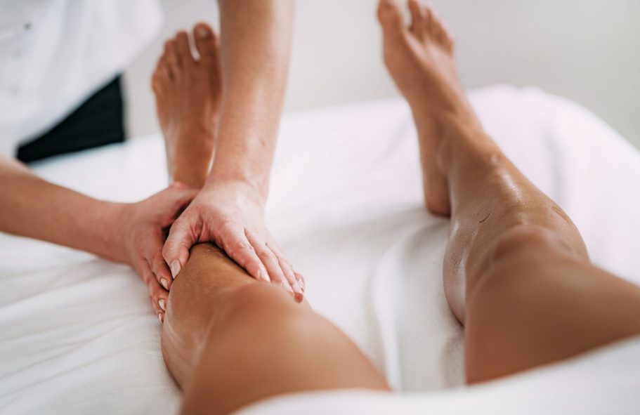 Massage on a person's legs, with hands applying pressure.