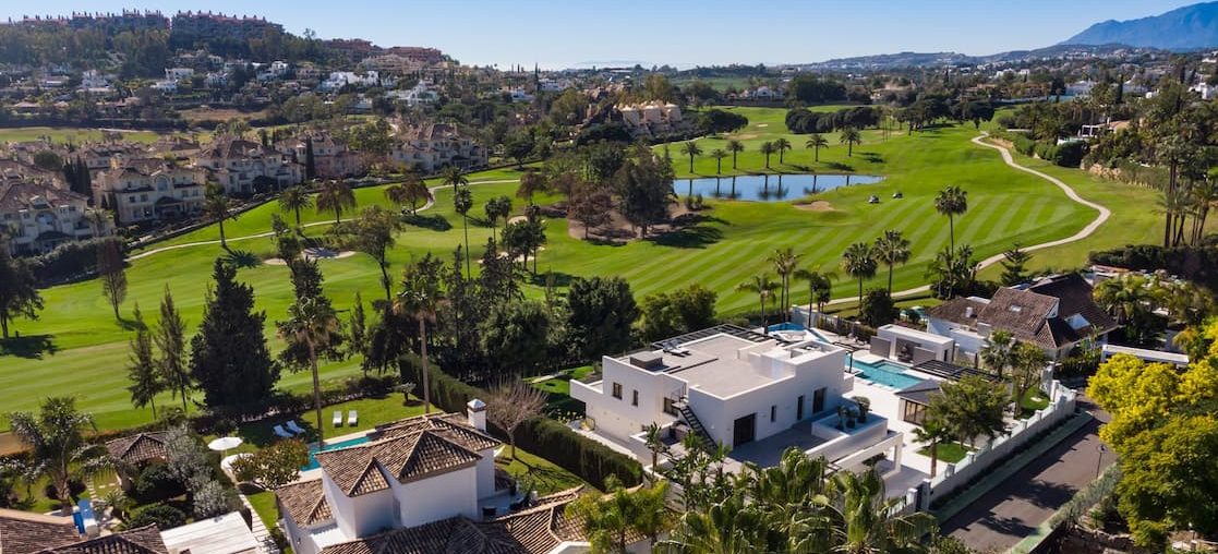 Exclusive Home Massage in Nueva Andalucia Panoramic view of a golf course in Nueva Andalucia with houses and surrounding vegetation.