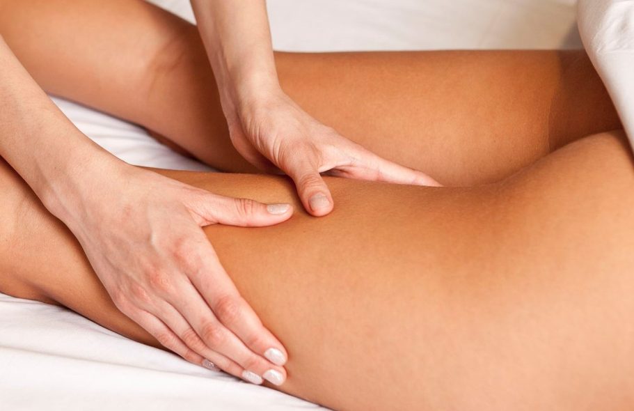 Hands massaging a bare thigh.