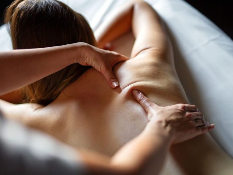 Massage on a person's back, with hands applying pressure and relaxation