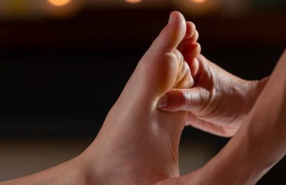One hand massages the sole of another person's foot.