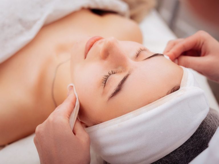 Woman receiving a facial treatment in the comfort of her home in Marbella
