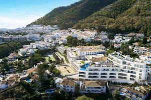 Panoramic view of Mijas, a white village on the Costa del Sol, surrounded by green mountains.