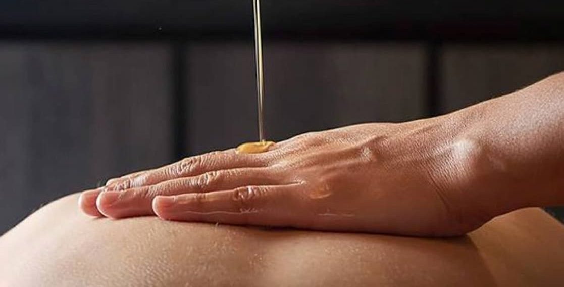 Exclusive Movil Massage Service in Puerto Banus Hand applying oil to a person's skin in a relaxing environment.