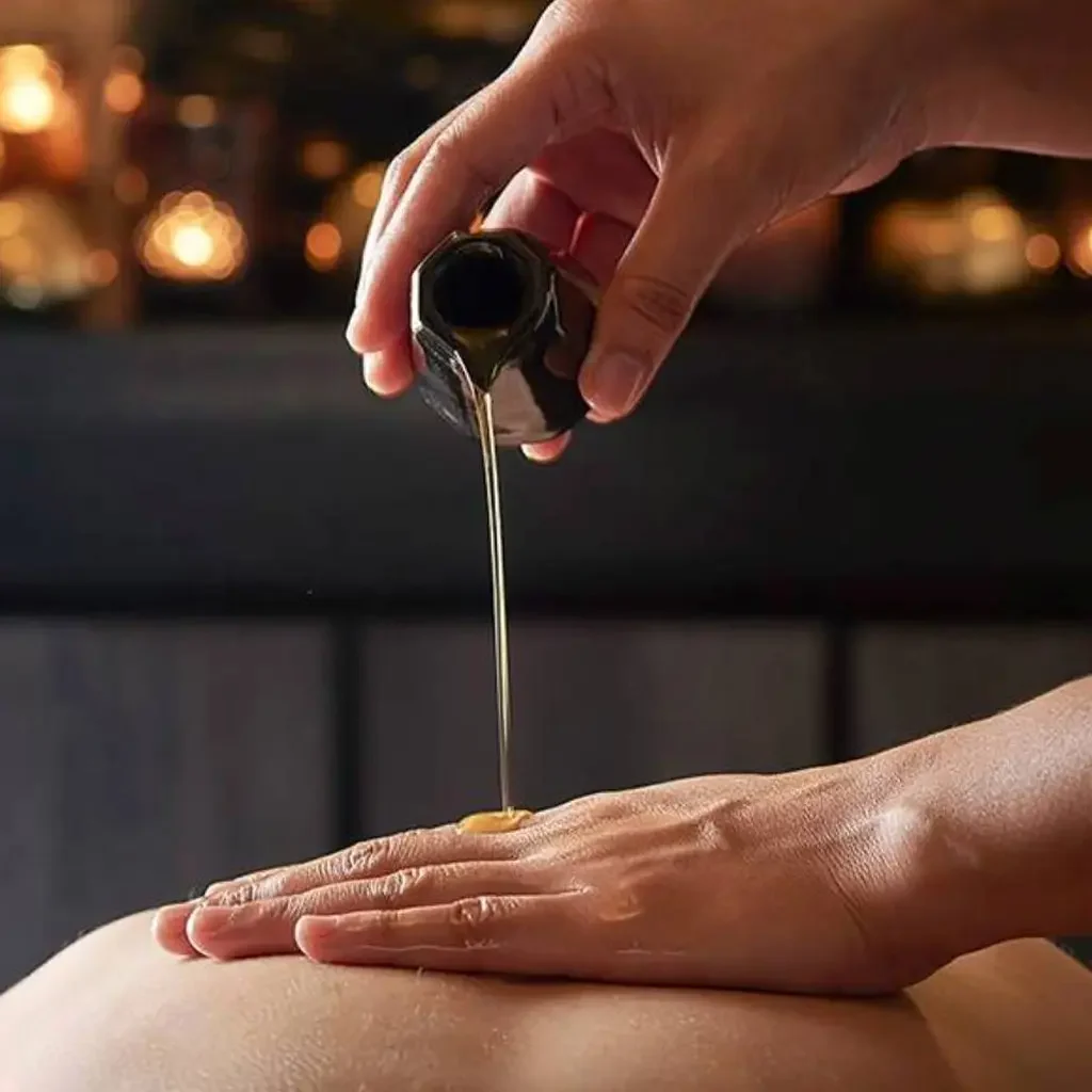 Hands massaging one arm on a soft surface.