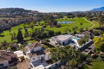 Aerial view of the Andalusia area, luxurious villa surrounded by golf courses and nature.