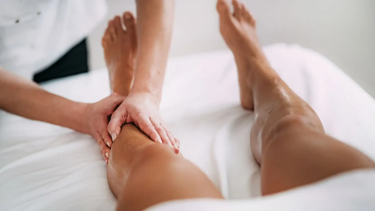 A leg massage on a person lying on a treatment table.